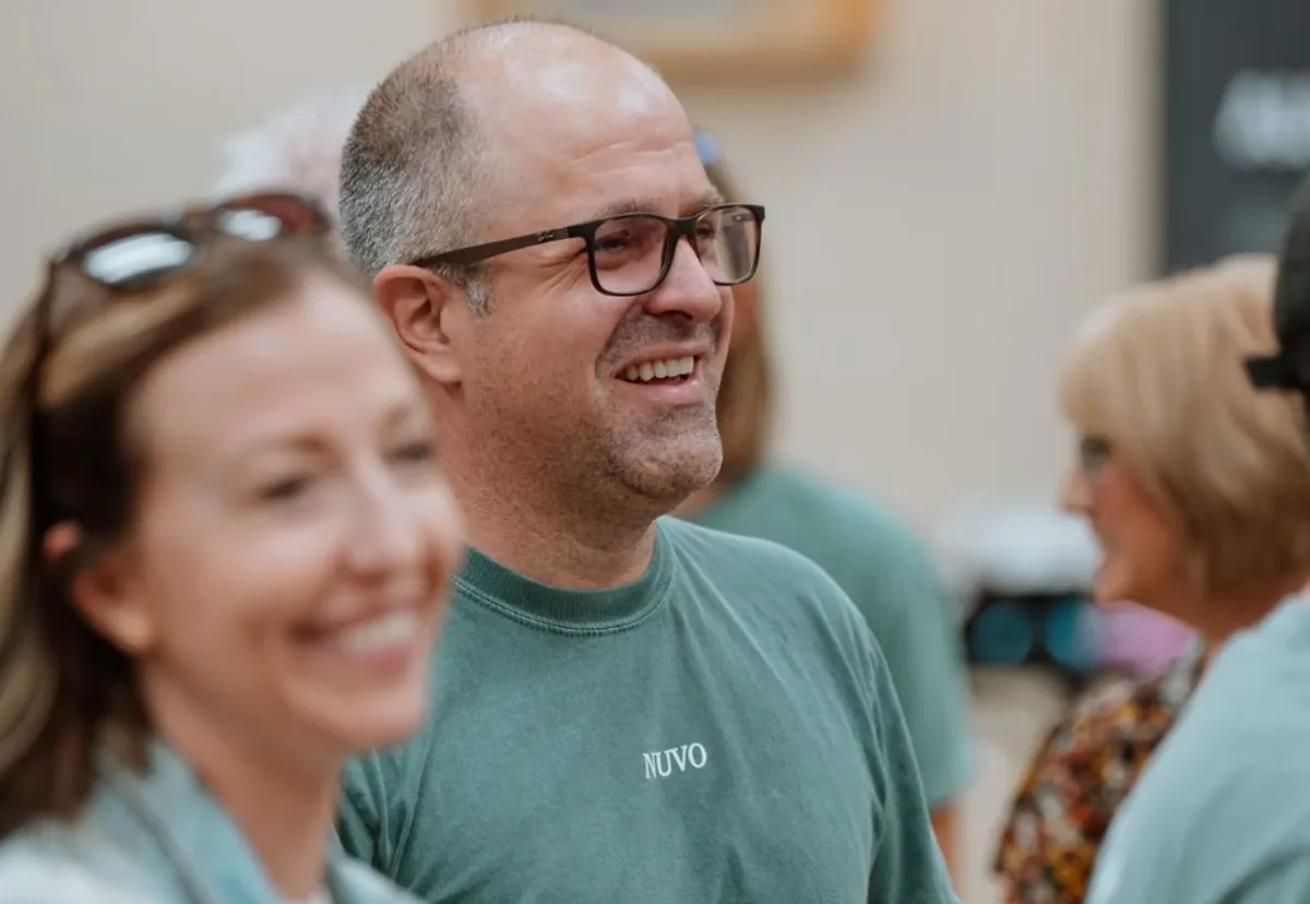Smiling man in a Nuvo shirt with friends on a Sunday at Nuvo Church in Columbus, Ohio