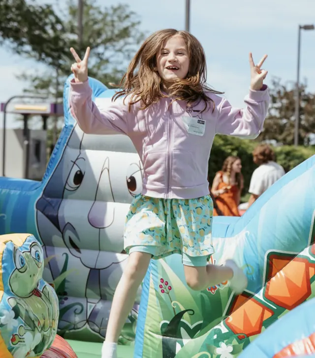 Girl jumping in a bounce house at a Nuvo Kids summer event in Dublin, Ohio