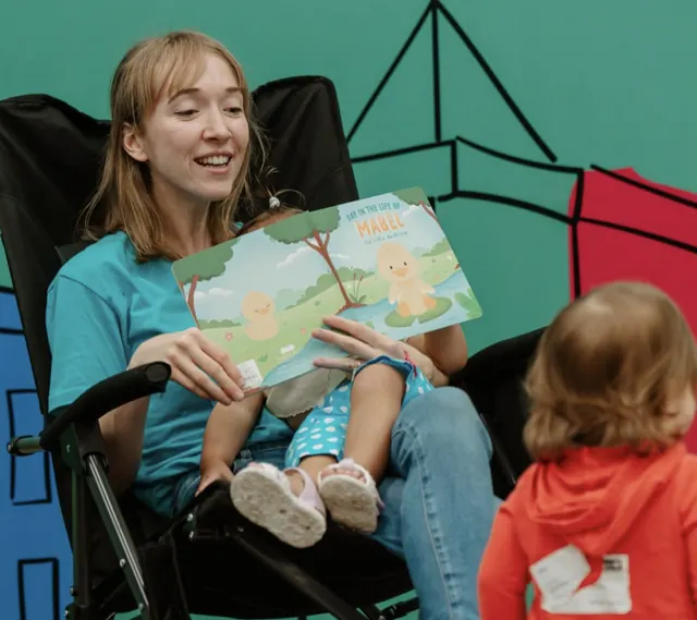 Nuvo Kids nursery volunteer reading a board book to babies at church in Dublin, Ohio