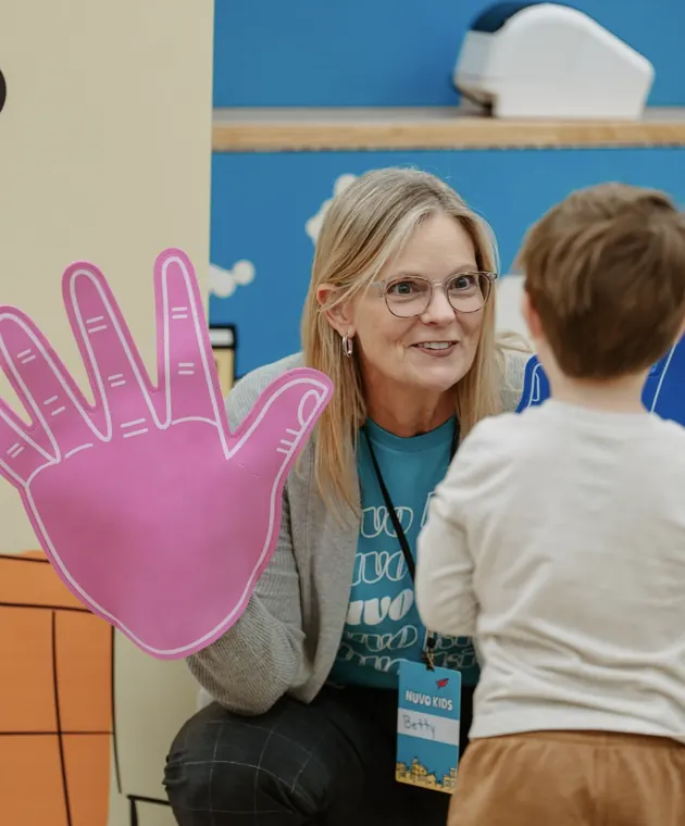 Nuvo Kids volunteer warmly greeting a child at check-in at church in Dublin, Ohio