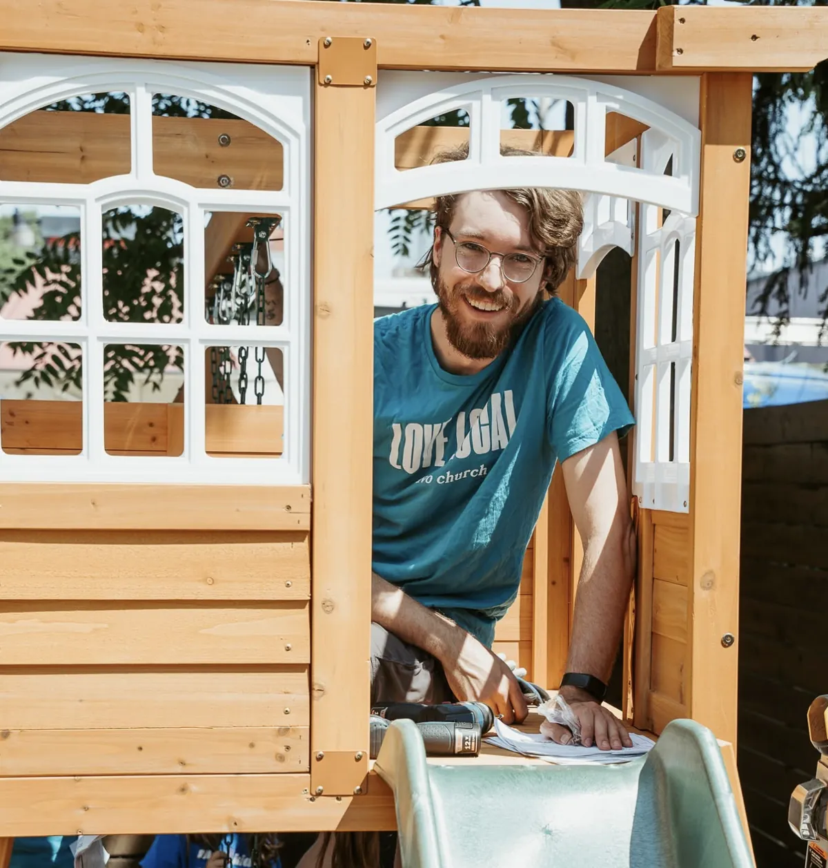 Smiling Nuvo Church volunteer inside a playhouse he helped build on a Love Local serve day in Columbus, Ohio