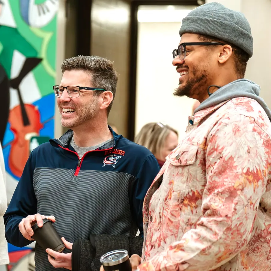 Friends laughing together before a Sunday service at Nuvo Church in Columbus