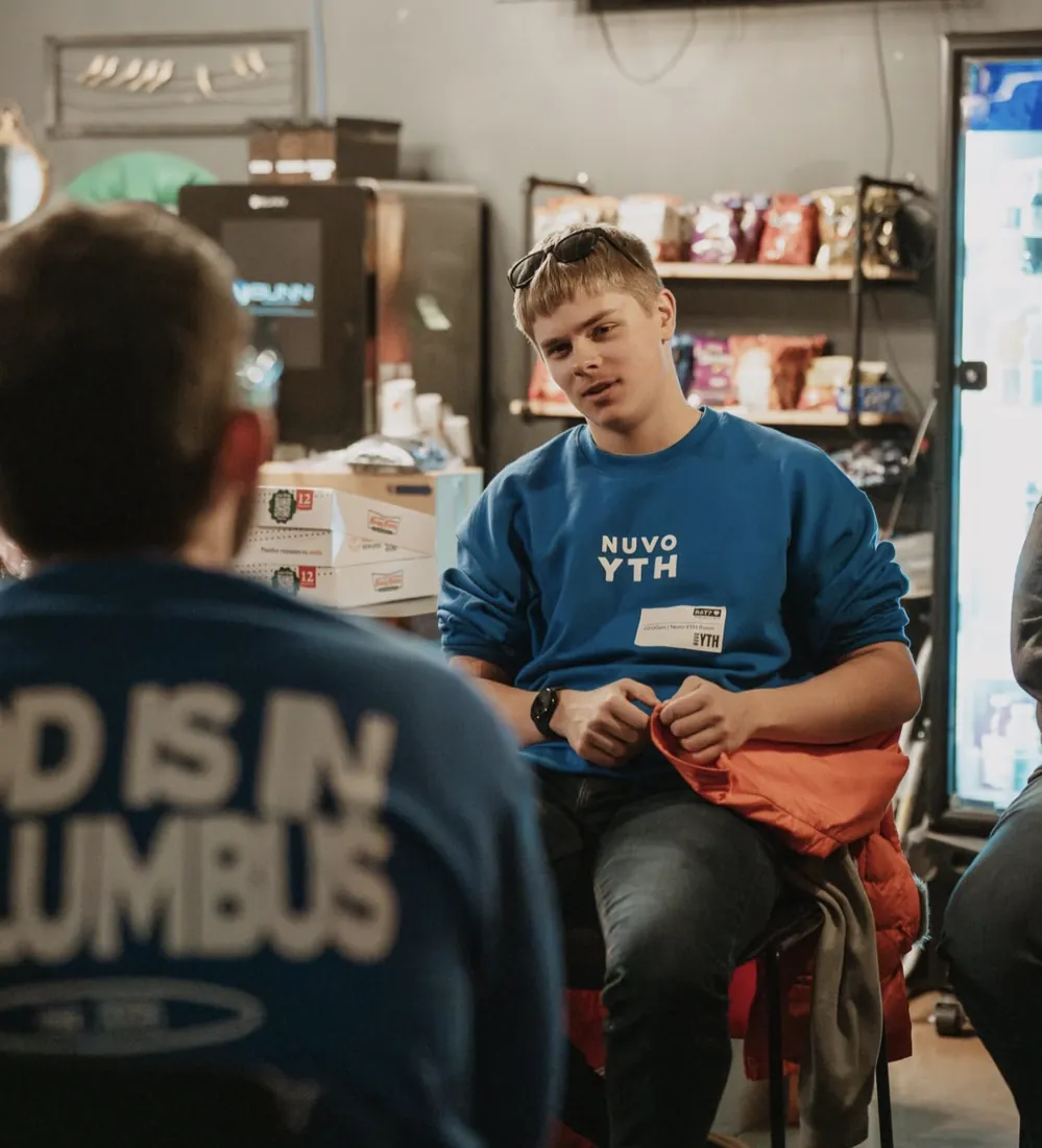 High school student in a Nuvo YTH sweatshirt talking in small group in Columbus