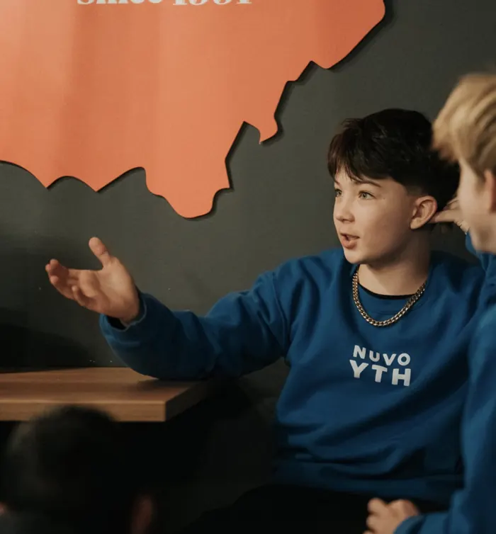 Middle school student in a Nuvo YTH sweatshirt sharing in small group at Nuvo Church in Columbus, Ohio