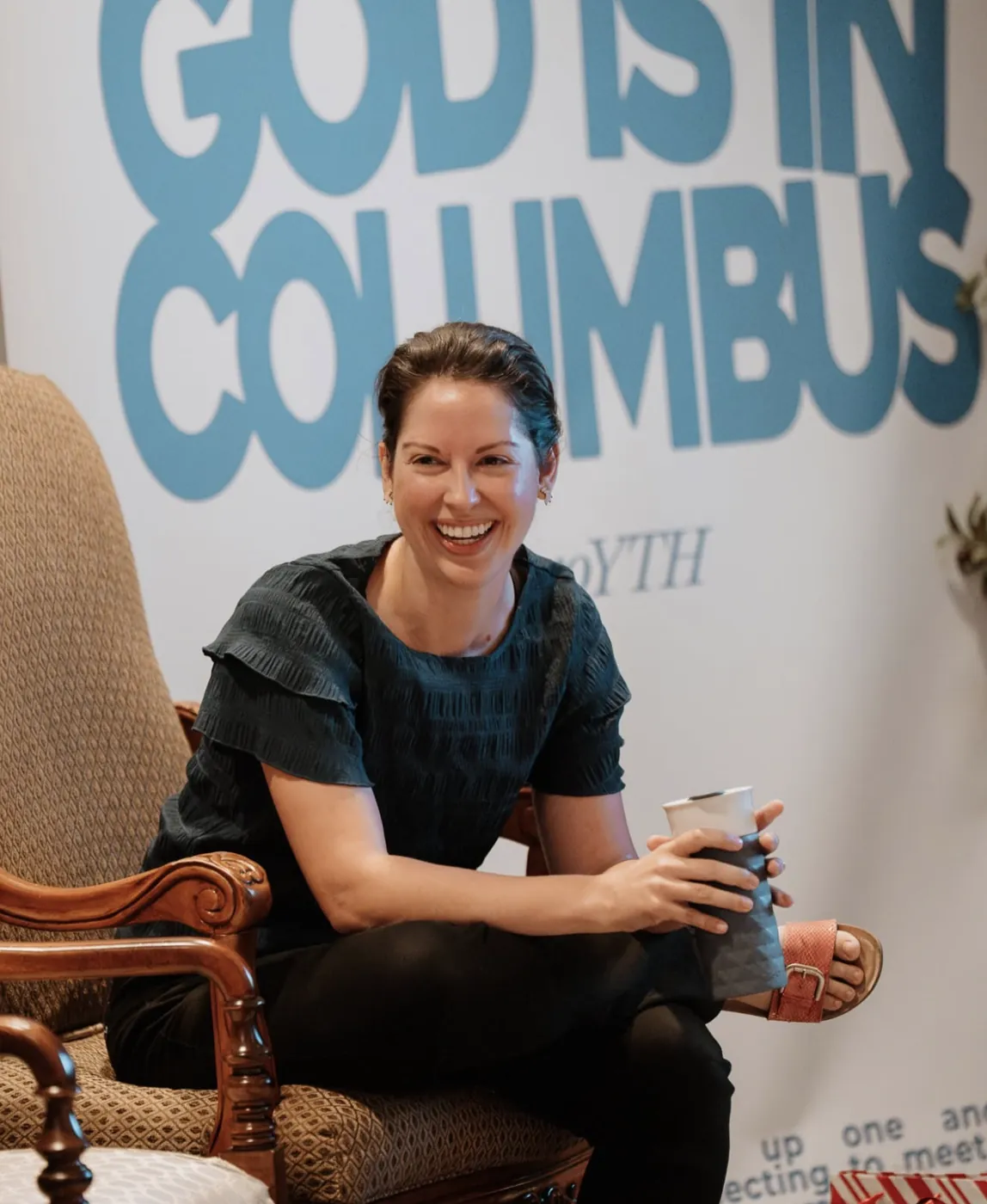 Nuvo YTH leader smiling in front of the God Is In Columbus banner in Dublin, Ohio